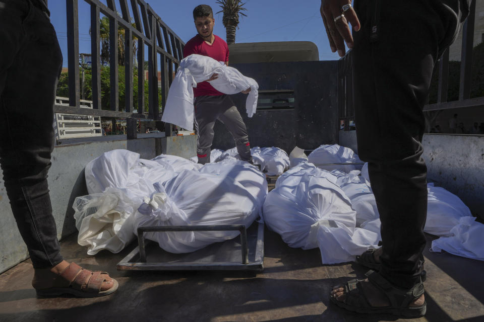 The bodies of people killed during an Israeli airstrike are loaded onto a truck outside al-Aqsa Hospital in Deir el-Balah, central Gaza Strip, Sunday, Oct. 15, 2023. (AP Photo/Adel Hana)