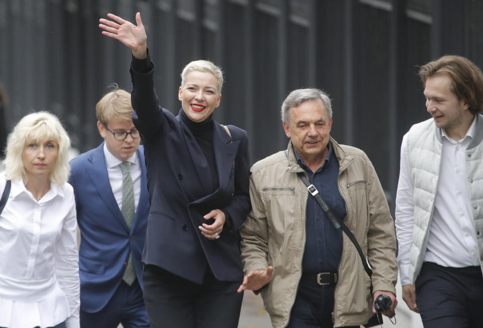 FILE - In this Aug. 27, 2020, file photo, Maria Kolesnikova, one of Belarus' opposition leaders, center left, and her father Alexander, center right, walk on the way to the Belarusian Investigative Committee in Minsk, Belarus. Kolesnikova, a professional flute player with no political experience, emerged as a key opposition activist in Belarus. She has appeared at protests of authoritarian President Alexander Lukashenko after he was kept in power by an Aug. 9 election that his critics say was rigged. (AP Photo/Dmitri Lovetsky, File)