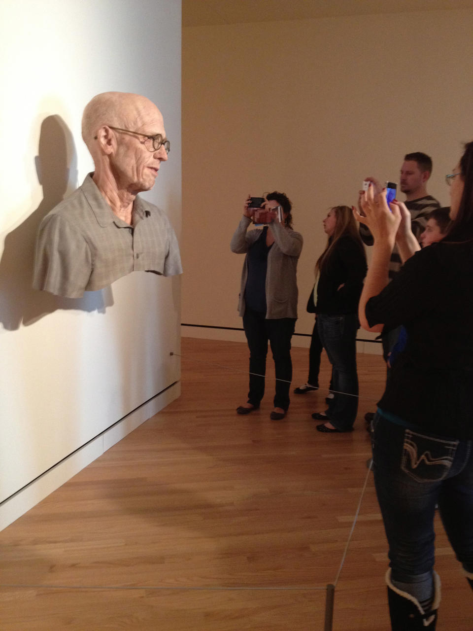 This Sunday, Feb. 26, 2012 photo shows patrons at Crystal Bridges Museum of American Art in Bentonville, Ark., looking at a sculpture by Evan Penny titled “Old Self: Portrait of the Artist as He Will (Not) Be. Variation #2." More than 175,000 people have visited the museum funded by Wal-Mart heiress Alice Walton since it opened in November 2012, bringing a major museum to the Southern Plains. Nearly four months after opening in November, the museum has already had over 175,000 visitors. (AP Photo/Chuck Bartels)