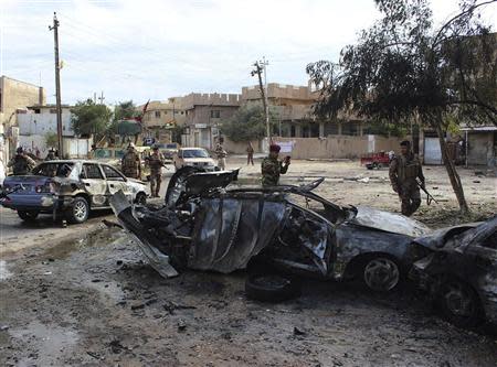 Iraqi security forces inspect the site of car bomb attack in Buhriz, 60 km (35 miles) northeast of Baghdad December 9 2013. REUTERS/Mohammed Adnan