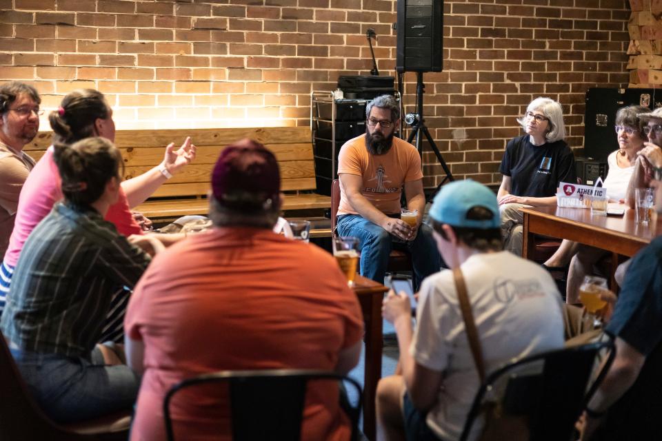 The Rev. Laura Patterson of Oconee Street United Methodist Church, left, asks Commissioner Tim Denson, center, questions regarding homelessness in Athens during their bi-weekly Not Church meeting on Thursday, July 14, 2022.