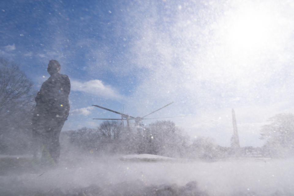 A U.S. Secret Service Special Agent stands as Marine One, with President Joe Biden aboard, lifts off from the South Lawn of the White House blowing snow with the rotor wash, Friday, Jan. 7, 2022, in Washington. Biden is en route to Colorado and Las Vegas. (AP Photo/Alex Brandon)