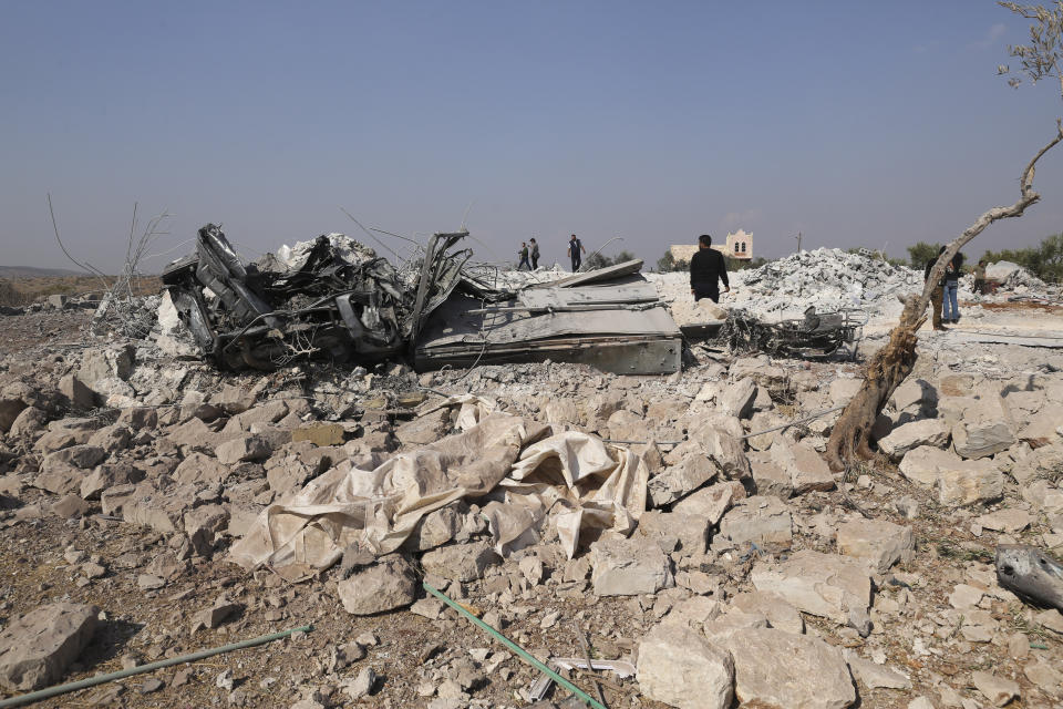 People look at a destroyed houses near the village of Barisha, in Idlib province, Syria, Sunday, Oct. 27, 2019, after an operation by the U.S. military which targeted Abu Bakr al-Baghdadi, the shadowy leader of the Islamic State group. President Donald Trump says Abu Bakr al-Baghdadi is dead after a U.S. military operation in Syria targeted the Islamic State group leader. (AP Photo/Ghaith Alsayed)