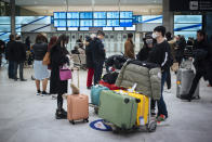 Travelers from Beijing, wearing masks, arrive at Charles de Gaulle airport, north of Paris, early Monday, Jan. 27, 2020. France's government announced Sunday it will repatriate up to hundreds of French citizens from the Chinese city of Wuhan, the epicenter of a deadly new virus. (AP Photo/Kamil Zihnioglu)
