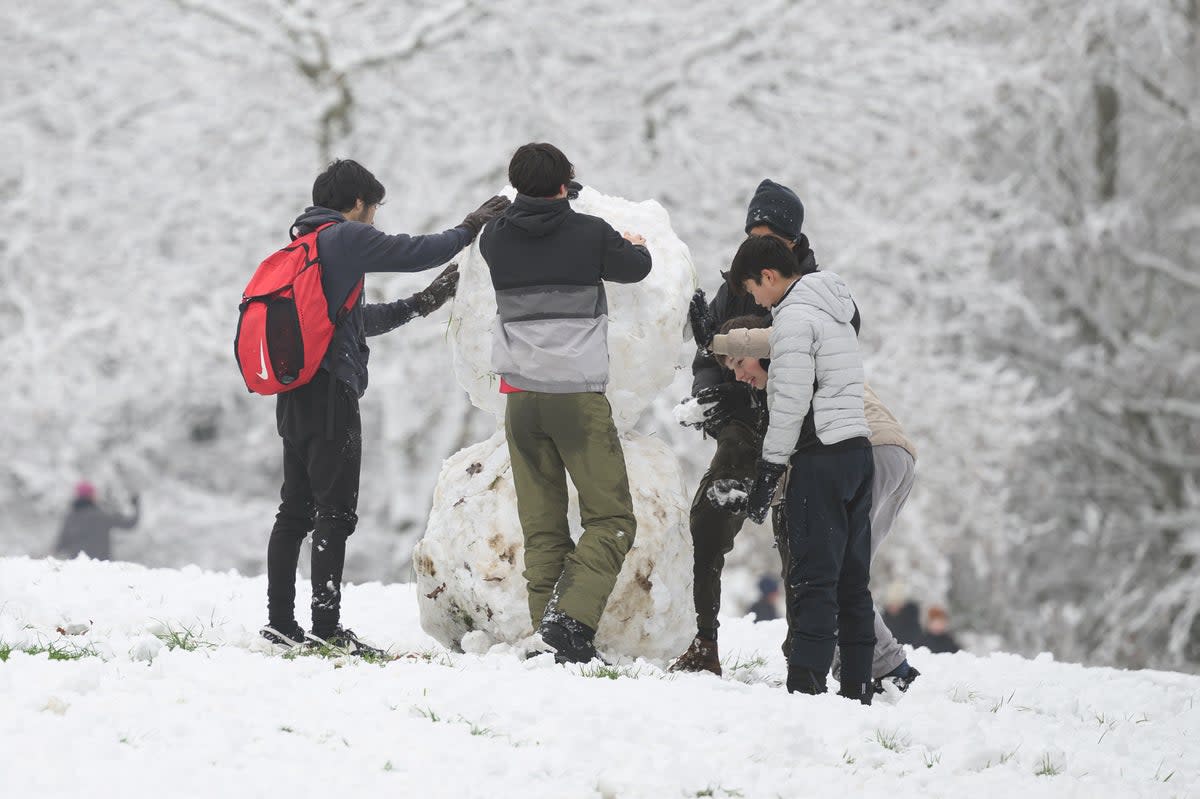 A group of children build a snowman in Alexandra Park on December 12, 2022 in London (Getty Images)