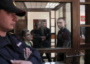 Russian soccer players Pavel Mamayev (R), Alexander Kokorin (L) and their acquaintance Alexander Protasovitsky, who are charged with a brutal assault and held in custody, are seen inside a defendants' cage as they attend a court hearing in Moscow, Russia May 6, 2019. REUTERS/Evgenia Novozhenina