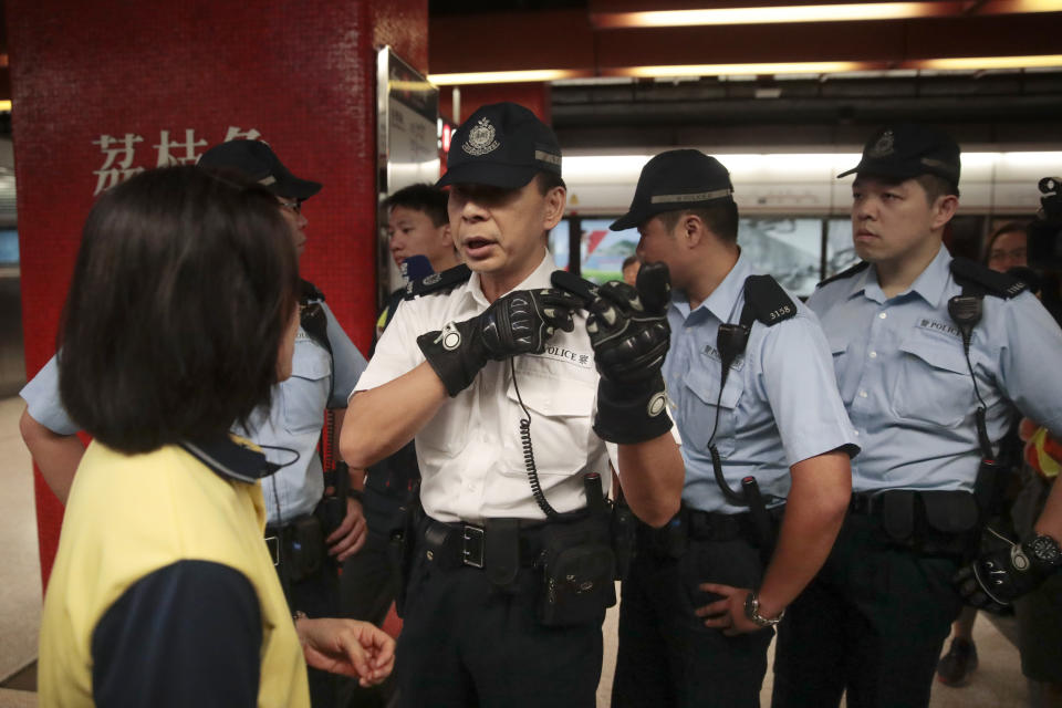 Police officers talks with train station staff as protesters trying to block train operation at a subway platform at Central in Hong Kong, on Monday, Sept. 2, 2019. Hong Kong has been the scene of tense anti-government protests for nearly three months. The demonstrations began in response to a proposed extradition law and have expanded to include other grievances and demands for democracy in the semiautonomous Chinese territory. (AP Photo/Jae C. Hong)