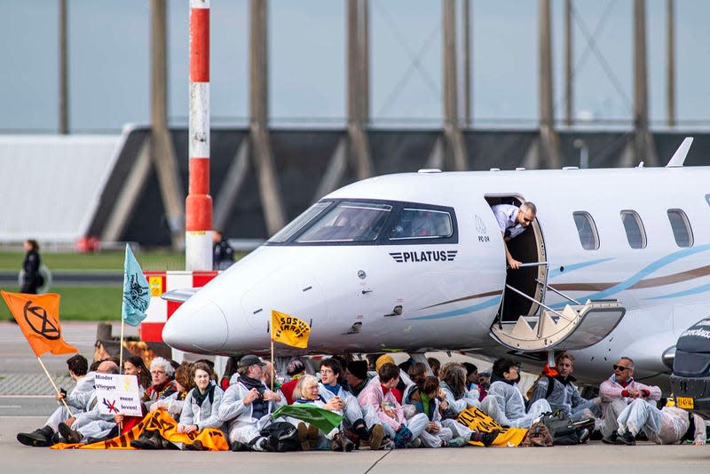 Greenpeace and Extinction Rebellion activists stop a private jet from taking off.