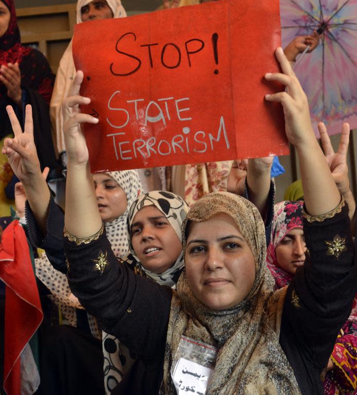 Pakistani supporters of cleric Tahir-ul-Qadri gather outside his residence in Lahore, on August 11, 2014