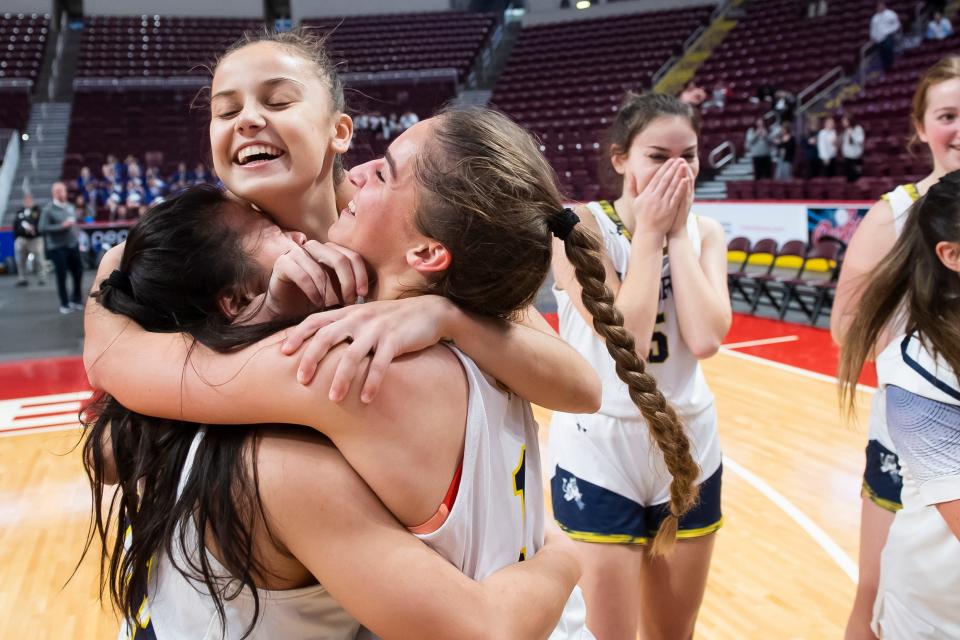 (From left) Greencastle-Antrim's Mia Libby, Rylee Henson and Haley Noblit hug on the court after winning the District 3 Class 5A girls' basketball championship at the Giant Center on March 2, 2023, in Derry Township. The Blue Devils defeated York Suburban, 44-30.