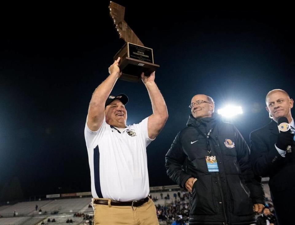 Central Catholic coach Roger Canepa is presented the state championship trophy after defeating San Marino for the CIF Open Division Small School title at California State University, Sacramento in Sacramento, Calif., on Saturday, Dec. 19, 2015.
