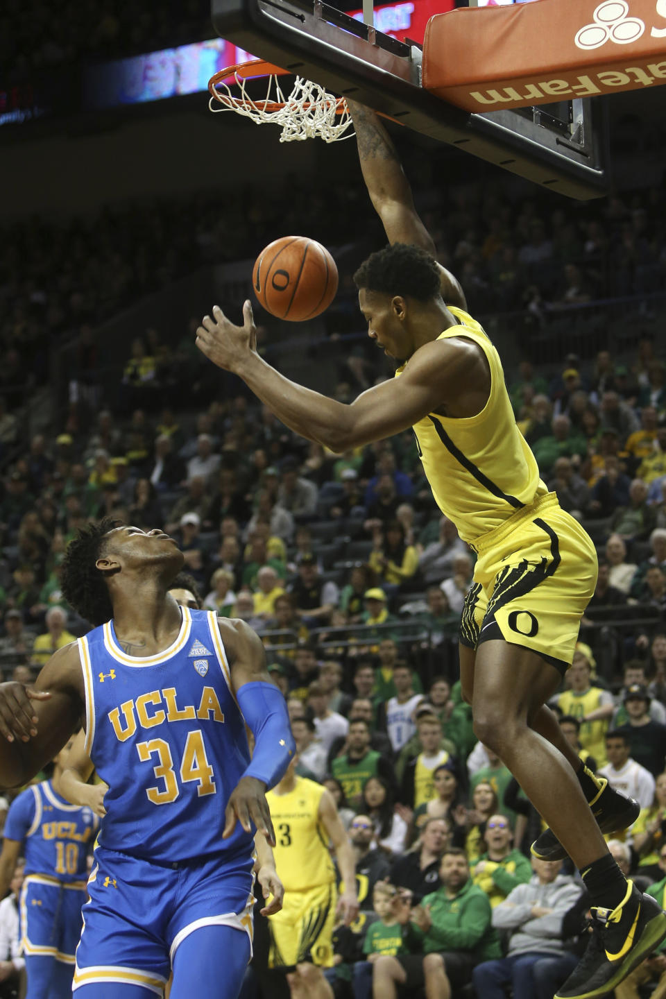 Oregon's Shakur Juiston, right, dunks the ball over UCLA's David Singleton during the first half of an NCAA college basketball game in Eugene, Ore., Sunday, Jan. 26, 2020. (AP Photo/Chris Pietsch)