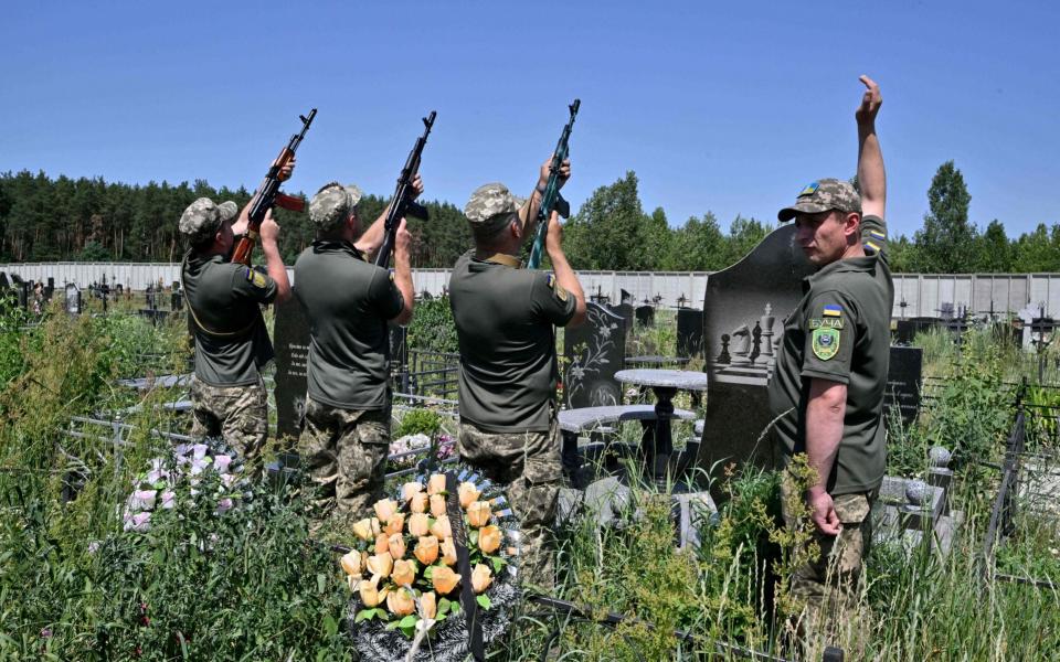 Servicemen fire a salvo in tribute to Ukrainian servicemen Vladislav Andreev killed in Donetsk region, during his funeral ceremony at Bucha's cemetery, not far from Kyiv on June 20, 2022 - SERGEI SUPINSKY/AFP via Getty Images