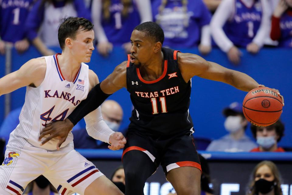 Texas Tech's Bryson Williams (11) attempts to get back Kansas' Mitch Lightfoot (44) during the first half of a Big 12 Conference game Tuesday inside Allen Fieldhouse in Lawrence, Kansas.