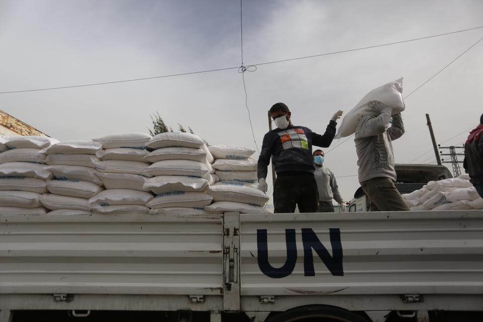 Palestinian employees at the U.N. Relief and Works Agency for Palestinian Refugees prepare food aid rations that will be delivered to people's homes due to the COVID-19 pandemic. (Photo: Majdi Fathi/NurPhoto via Getty Images)