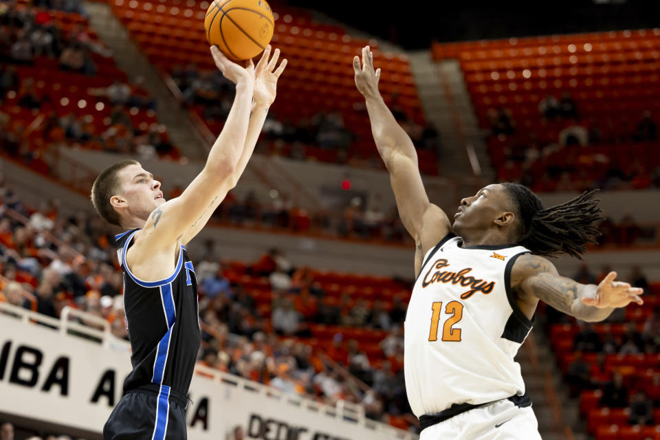 BYU forward Noah Waterman (0) shoots over Oklahoma State guard Javon Small (12) in the first half of the NCAA college basketball game, Saturday, Feb. 17, 2024, in Stillwater, Okla. (AP Photo/Mitch Alcala)