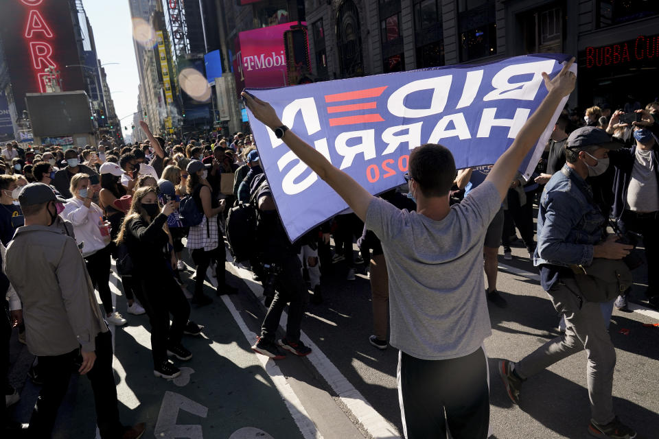 People celebrate in Times Square after Joe Biden was announced as the winner. (AP Photo/Seth Wenig)