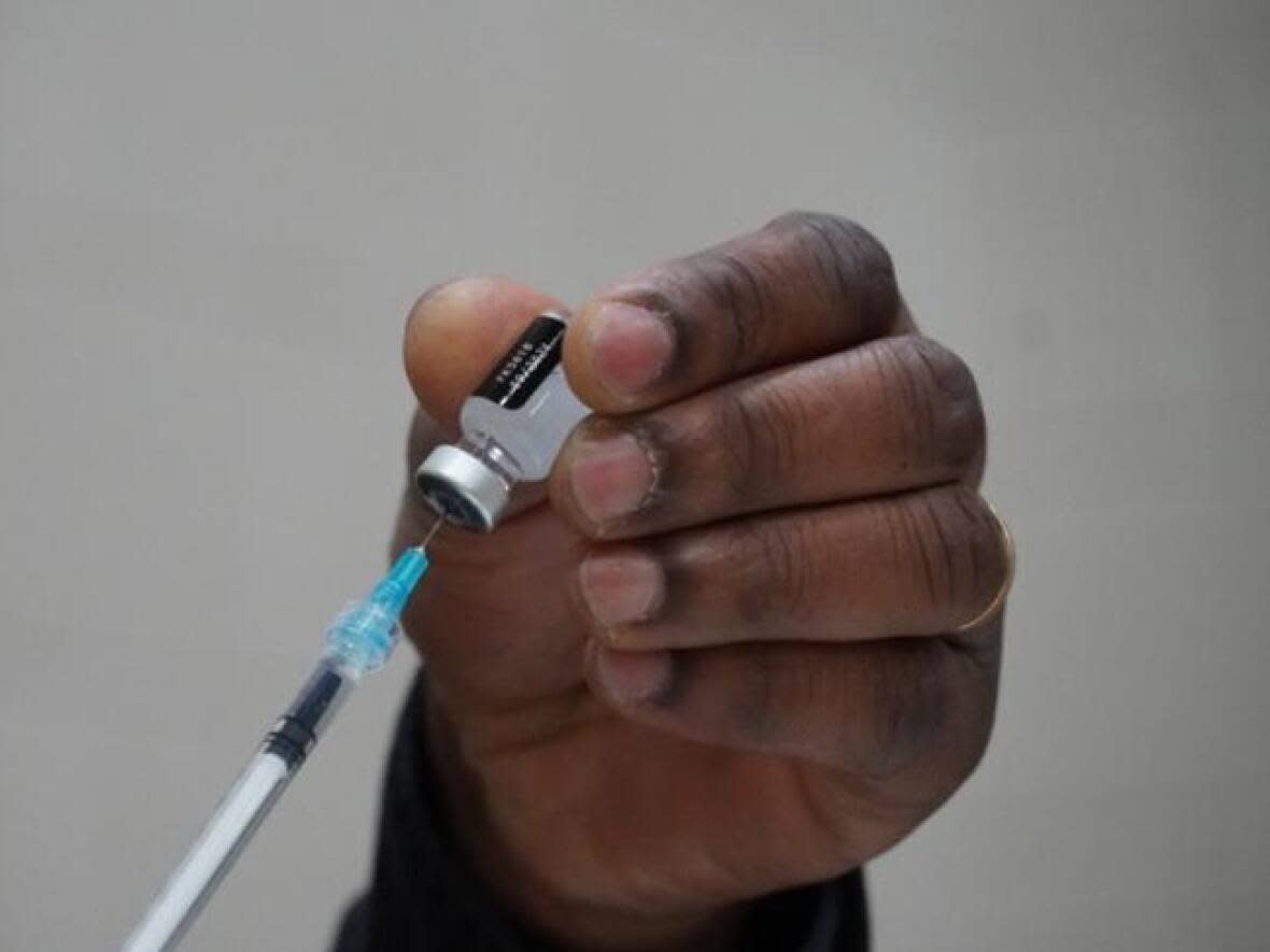 A man prepares a dose of the pediatric COVID-19 vaccine made by Pfizer-BioNTech at a clinic at a Gatineau, Que., elementary school last month. (Jacques Corriveau/Radio-Canada - image credit)