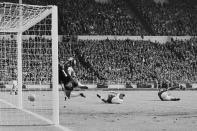 <p>Drin oder nicht drin? Diese Frage spaltet bis heute Fußballfans, wenn es um das berühmt-berüchtigte Wembley-Tor geht. Im WM-Finale 1966 flog ein Schuss von Geoff Hurst am deutschen Torwart Hans Tilkowski vorbei, prallte aber von der Latte aufs Feld zurück. Ob der Ball in vollem Umfang hinter der Linie war, ist noch immer unklar. Fest steht: Das Tor zum 3:2 für England zählte und machte den Weg frei für den WM-Titel der "Three Lions". (Bild: Central Press / Getty Images)</p> 