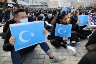 Manifestantes de Hong Kong sostienen banderas uigures del Turquestán Oriental en un acto de apoyo a los derechos humanos de los uigures del Xinjiang en Hong Kong