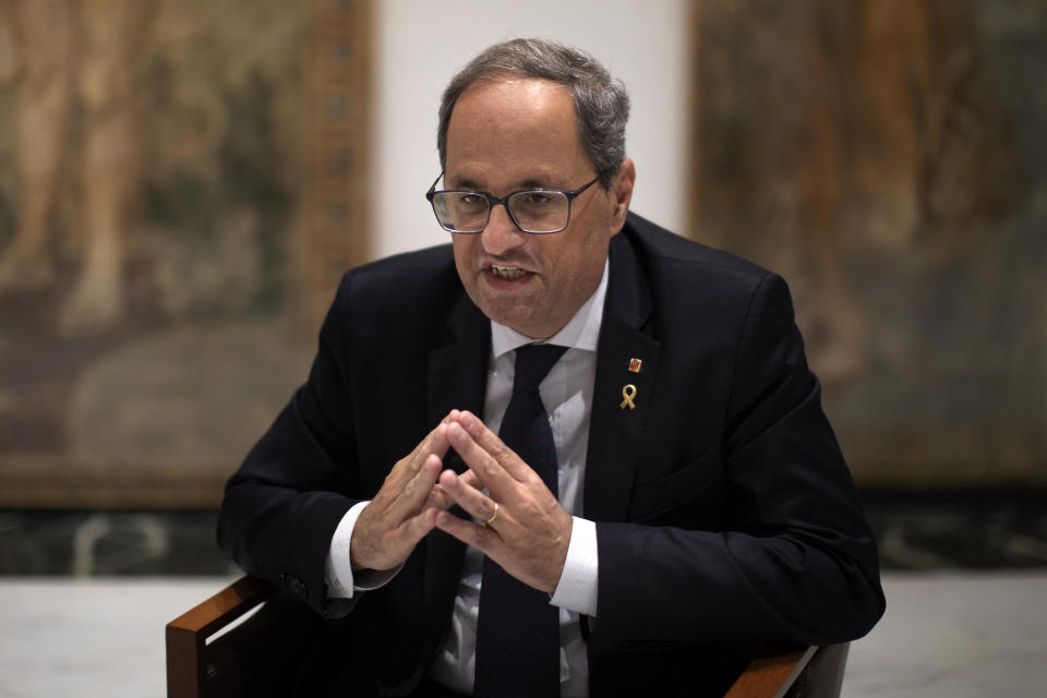 Catalan regional president Quim Torra talks with a journalist at the headquarters of the Government of Catalonia, during an interview with The Associated Press in Barcelona, Spain, Monday, Oct. 21, 2019. The leader of Catalonia says that the massive protests that have often spiralled into violent clashes with police this week won't cease until the Spanish government accepts to listen to separatists' demands. (AP Photo/Emilio Morenatti)