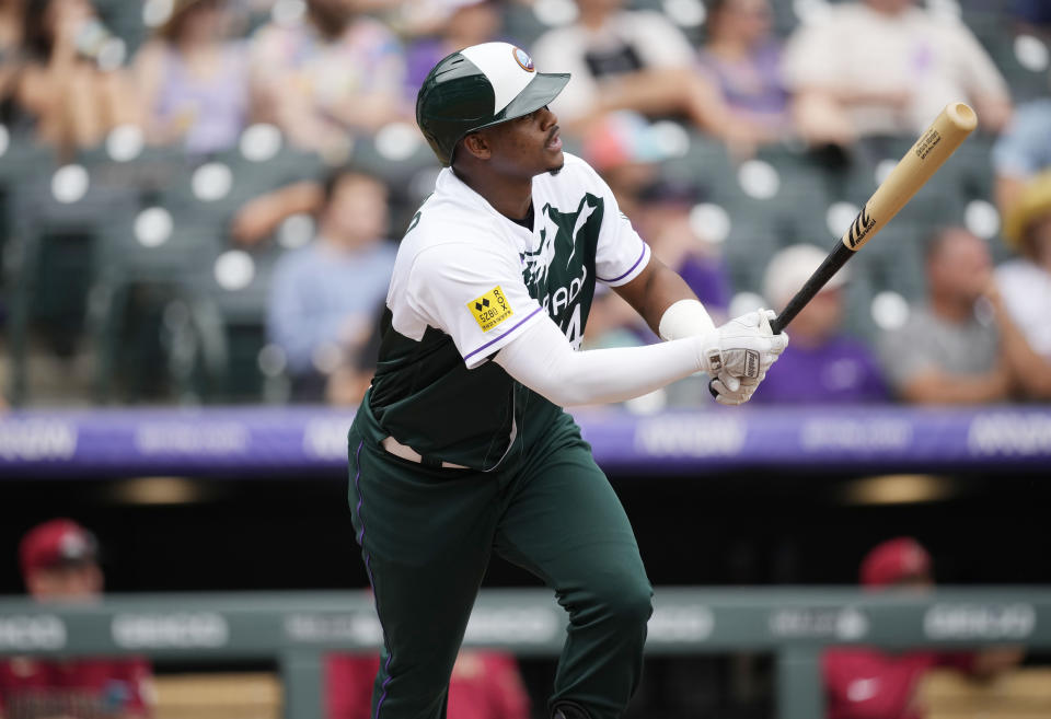 Colorado Rockies' Elehuris Montero follows the flight of his RBI-double off Arizona Diamondbacks starting pitcher Tommy Henry in the sixth inning of a baseball game Sunday, Aug. 14, 2022, in Denver. (AP Photo/David Zalubowski)