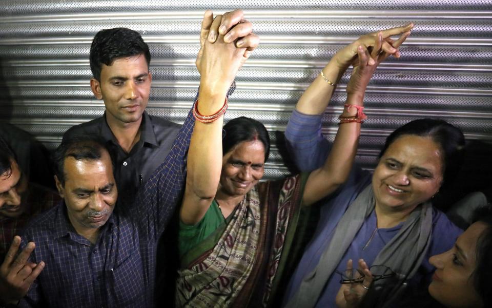 The father (L) and mother (C) of a 2012 murder and gang rape victim celebrate after the hanging of the convicted attackers - Shutterstock