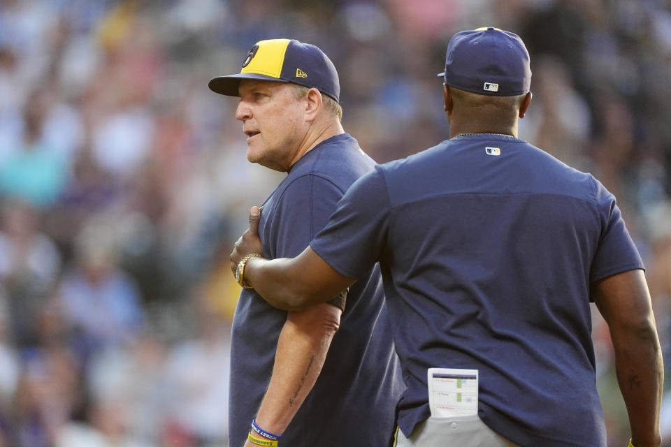 Milwaukee Brewers associate manager Rickie Weeks Jr., right, guides manager Pat Murphy, left, to the clubhouse after Murphy was ejected for arguing a call by home plate umpire Brennan Miller in the fifth inning of a baseball game against the Colorado Rockies, Monday, July 1, 2024, in Denver. (AP Photo/David Zalubowski)