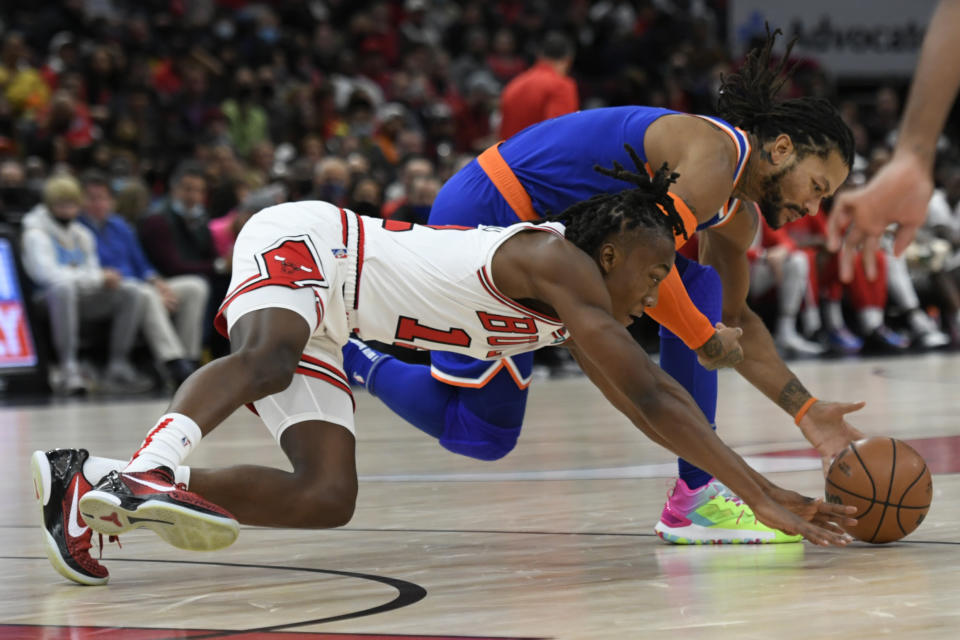 New York Knicks' Derrick Rose battles Chicago Bulls' Ayo Dosunmu (12) for a loose ball during the first half of a NBA basketball game Sunday, Nov. 21, 2021 in Chicago. (AP Photo/Paul Beaty)