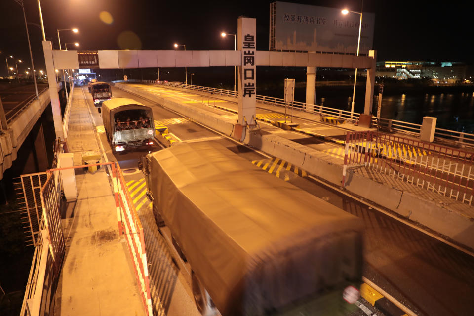 In this photo released by China's Xinhua News Agency, trucks carrying soldiers from China's People's Liberation Army (PLA) pass through the Huanggang Port border between China and Hong Kong, Thursday, Aug. 29, 2019. Chinese state media has published photos of the country's Hong Kong-based troops' armored carriers and a patrol boat undertaking what they call a routine rotation. (Yuan Junmin/Xinhua via AP)