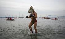 A man wearing a goat mask runs into the English Bay during the annual New Year's Day Polar Bear Swim in Vancouver, British Columbia January 1, 2013.