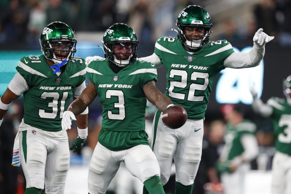 New York Jets safety Jordan Whitehead celebrates with cornerback Craig James and safety Tony Adams.