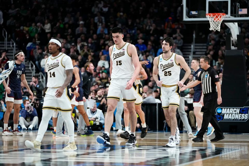 Mar 17, 2023; Columbus, Ohio, USA;  Purdue Boilermakers guard David Jenkins Jr. (14), center Zach Edey (15) and guard Ethan Morton (25) walk to the bench during a timeout during the first round of the NCAA men’s basketball tournament against the Fairleigh Dickinson Knights at Nationwide Arena. The No. 16 seed Knights won 63-58. Mandatory Credit: Adam Cairns-The Columbus Dispatch