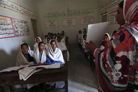 A teacher displays a flash card to students while describing preventive measures to take when sexual harassment occurs, during a class in Shadabad Girls Elementary School in Pir Mashaikh village in Johi, some 325 km (202 miles) from Karachi February 12, 2014. REUTERS/Akhtar Soomro