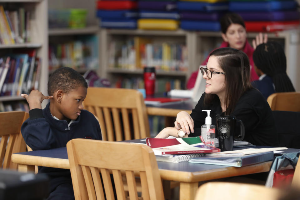 In this Tuesday, Dec. 18, 2018 photo, speech therapist Sadie Haas talks with Zion Odia, a 6th grader, during annual hearing and speech examinations, at Alice M. Harte Charter School in New Orleans. Charter schools, which are publicly funded and privately operated, are often located in urban areas with large back populations, intended as alternatives to struggling city schools. (AP Photo/Gerald Herbert)