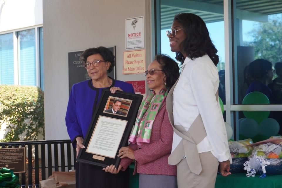 Kristen Cooper, right, dedicated a bench on Sunday memorializing the life and legacy of the late U.S. District Judge Stephan P. Mickle that she donated to Lincoln Middle School as part of her Girl Scout Gold Project. She is pictured here with the late judge's mother, Catherine Mickle, left, and his wife, Evelyn Mickle, center.
(Credit: Photo by Voleer Thomas, Correspondent)