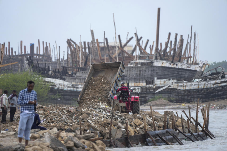 A tractor is used to make a wall to prevent sea water entering on the Arabia Sea coast at Mandvi in Kutch district of Gujarat state, India, Wednesday, June 14, 2023. With Cyclone Biparjoy expected to make landfall Thursday evening, coastal regions of India and Pakistan are on high alert. (AP Photo/Ajit Solanki)