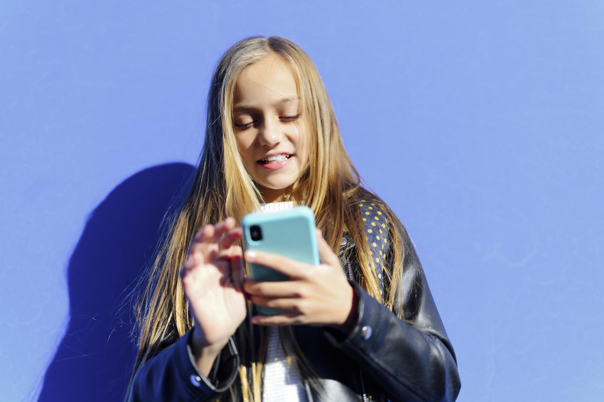 A young girl uses a smartphone.