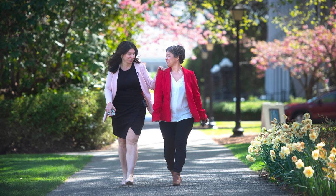 Washington state Rep. Michelle Caldier (left) holds the shoulder of her legislative assistant, Loujanna “LJ” Rohrer as they walk through the Capitol Campus in Olympia, Washington, on Wednesday, May 3, 2023. Caldier lost her eyesight to glaucoma 2016. Tony Overman/toverman@theolympian.com