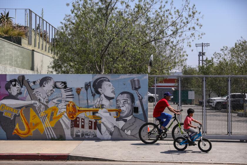 Los Angeles, CA - June 16: People rides their bikes in front of the 9th district office as corruption charges were filed against Councilman Curren Price on Friday, June 16, 2023 in Los Angeles, CA. (Jason Armond / Los Angeles Times)