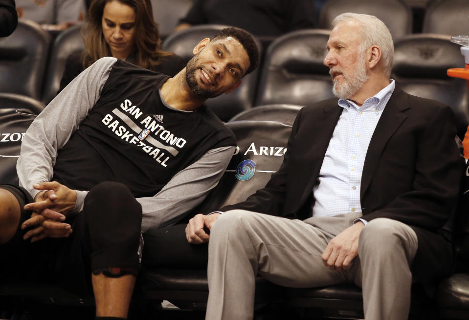 FILE - In this Feb. 28, 2015, file photo, San Antonio Spurs forward Tim Duncan, left, and head coach Gregg Popovich chat on the bench during the first quarter of an NBA basketball game against the Phoenix Suns in Phoenix. They were joined at the hip for 19 years, a player and coach combination that enjoyed more wins than any in NBA history. And now that Duncan's playing days are done, Popovich is about to start anew in some respects. (AP Photo/Rick Scuteri, File)