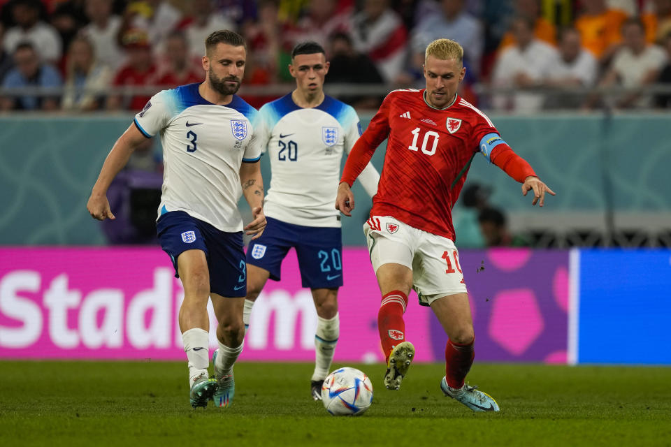 Wales' Aaron Ramsey, right, vies for the ball with England's Luke Shaw, left, and Phil Foden during the World Cup group B soccer match between England and Wales, at the Ahmad Bin Ali Stadium in Al Rayyan , Qatar, Tuesday, Nov. 29, 2022. (AP Photo/Frank Augstein)