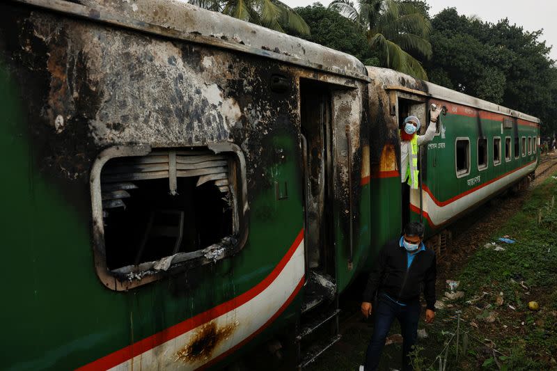 Crime Scene Unit members inspect the passenger train that was set on fire during a countrywide strike called by the Bangladesh Nationalist Party, in Dhaka