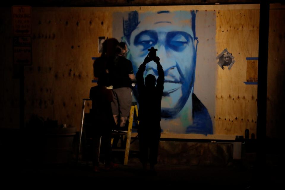 An artist creates an image of George Floyd in Minneapolis as protests over his death broke out in Minneapolis for a third straight night: AP