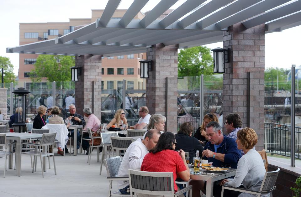 Customers dine along the river on the patio at the Hilton Garden Hotel on May 21, 2015.