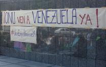 Letreros en los que se solicita que una misión de la ONU visite Venezuela fueron colocados en las oficinas de esta organización en Caracas, este martes 25 de marzo de 2014. Opositores y el presidente venezolano Nicolás Maduro se reunieron con una misión de cancilleres de Unasur que visitaron el país para fomentar el diálogo entre ambas partes. (Foto de AP/Fernando Llano)