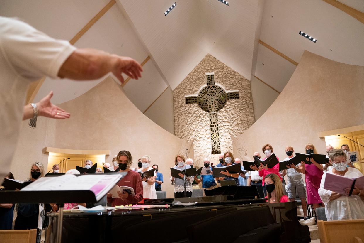 Doug Renfroe, left, conducts during a Voices of Naples rehearsal at Grace Lutheran Church in Naples on Monday, February 22, 2021. 