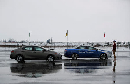 A self-driving car drives by a parked car and a mannequin during a demonstration at the Renesas Electronics autonomous vehicle test track in Stratford, Ontario, Canada, March 7, 2018. REUTERS/Mark Blinch