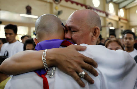 A priest embraces Saldy, father of Kian delos Santos, a 17-year-old student who was shot during anti-drug operations during a funeral mass inside a church Caloocan, Metro Manila, Philippines August 26, 2017. REUTERS/Dondi Tawatao