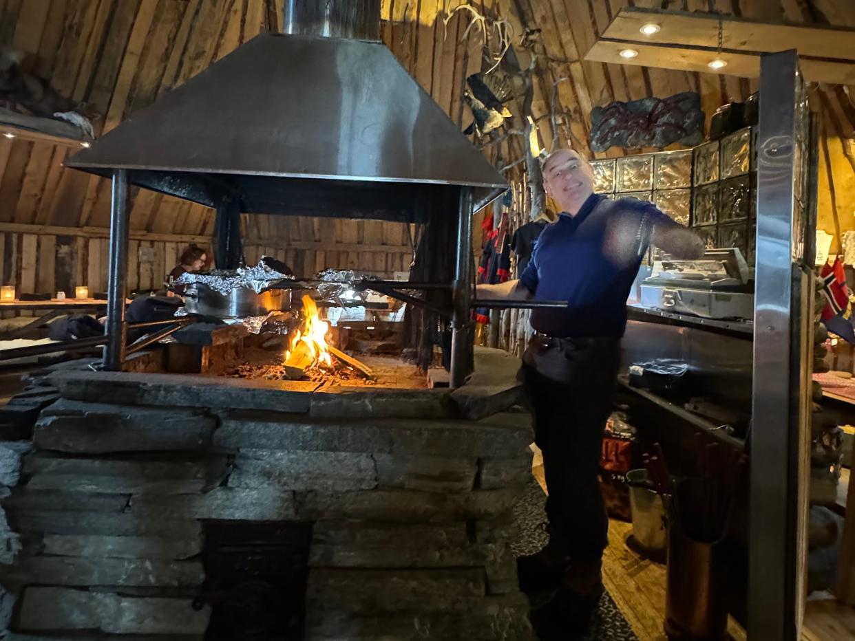 A chef grilling reindeer sausages at Snowhotel Kirkenes' restaurant